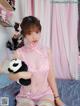 A woman in a pink lingerie holding a stuffed panda bear.