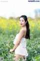 A woman in a white dress standing in a field of flowers.