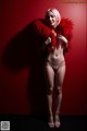 A naked woman in a red fur coat posing for a picture.