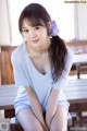 A woman sitting on top of a wooden bench.