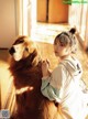 A woman sitting on the floor next to a dog.