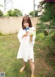 A woman in a white dress holding a water gun.