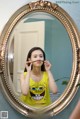 A woman brushing her teeth in front of a mirror.