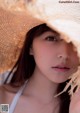 A woman wearing a straw hat is posing for a picture.