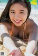 A woman laying on the sand on a beach.