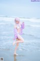 A woman in a bikini standing on the beach.