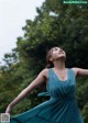 A woman in a blue dress standing in the rain.