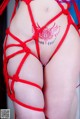 A woman in a red string bikini with a tattoo on her back.